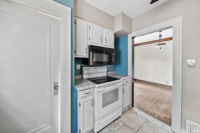 2217 Inglewood Pl, South Bend, IN 46616 - kitchen featuring black microwave, white electric range oven, white cabinets, baseboards, and light tile patterned flooring