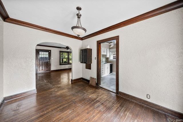 2217 Inglewood Pl, South Bend, IN 46616 - unfurnished room with arched walkways, a textured wall, dark wood-style flooring, crown molding, and baseboards