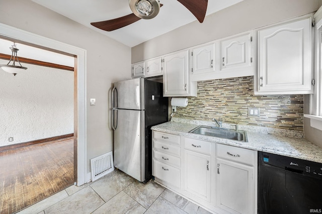 2217 Inglewood Pl, South Bend, IN 46616 - kitchen with a sink, freestanding refrigerator, black dishwasher, a ceiling fan, and white cabinets