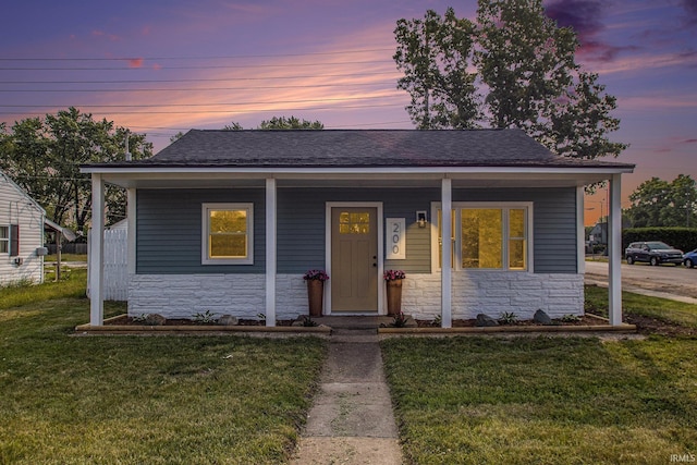 200 Johnson St, Elkhart, IN 46516 - view of front of property with stone siding, a yard, a porch, and roof with shingles
