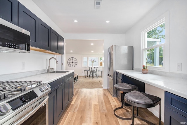 200 Johnson St, Elkhart, IN 46516 - kitchen with appliances with stainless steel finishes, a sink, light wood-style floors, recessed lighting, and light stone counters