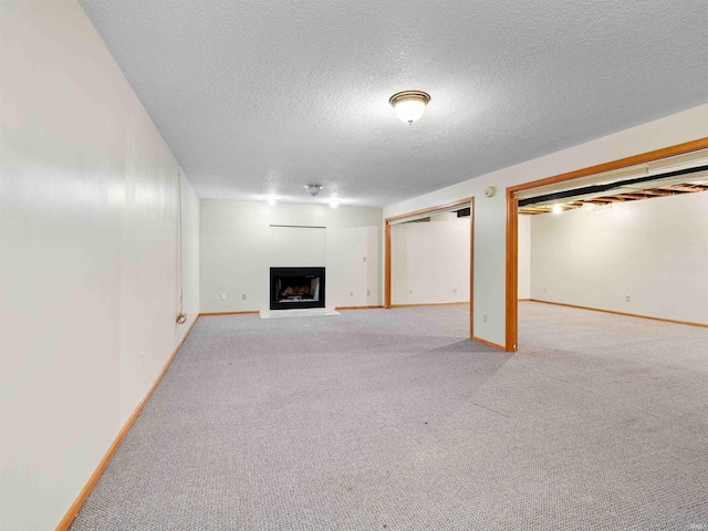 509 Water Meade Pl, Fort Wayne, IN 46825 - finished below grade area with carpet, a fireplace with flush hearth, a textured ceiling, and baseboards