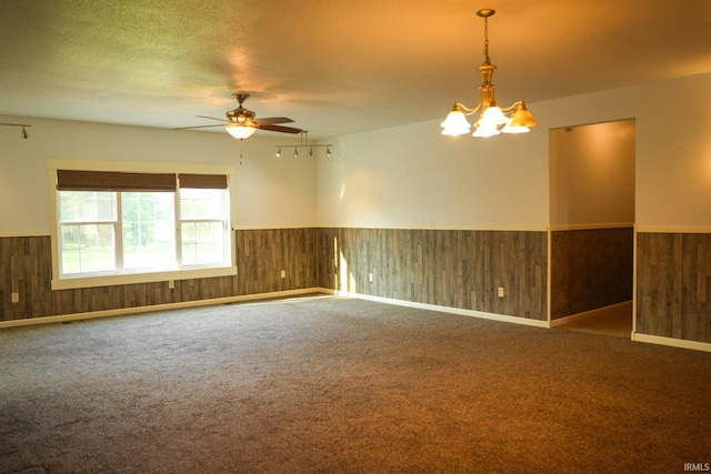 7458 E Lincolnway Rd, Columbia City, IN 46725 - carpeted empty room with a wainscoted wall, wood walls, a ceiling fan, and a chandelier