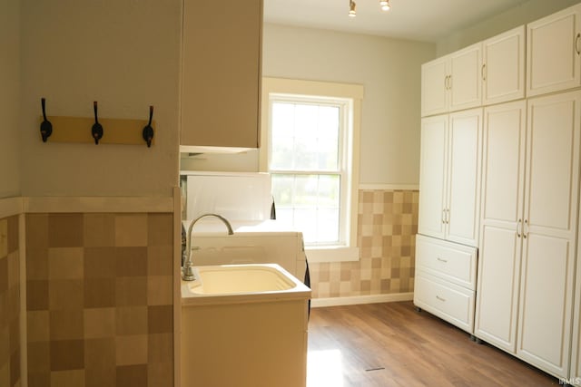7458 E Lincolnway Rd, Columbia City, IN 46725 - laundry room with a sink, light wood-style floors, washer / clothes dryer, and a wainscoted wall