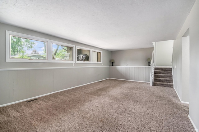 1708 Canterbury Dr, Elkhart, IN 46514 - carpeted spare room featuring a textured ceiling, stairs, and baseboards