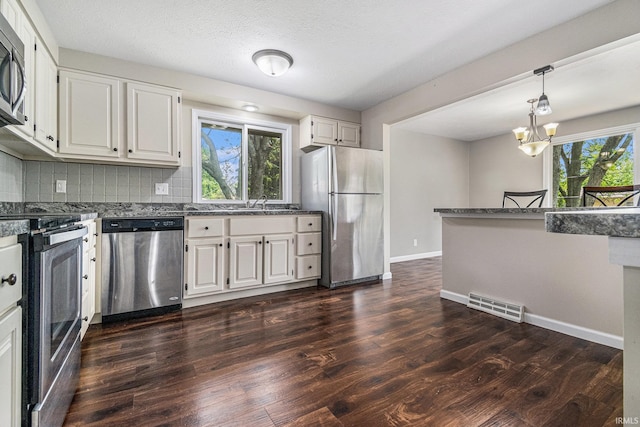 1708 Canterbury Dr, Elkhart, IN 46514 - kitchen with appliances with stainless steel finishes, dark wood-style floors, healthy amount of natural light, and decorative backsplash