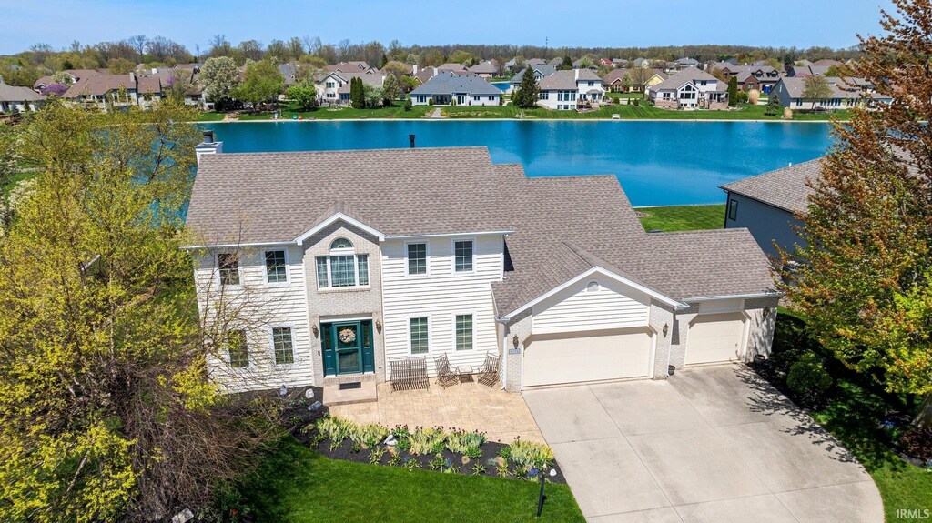 9529 Skipjack Cv, Fort Wayne, IN 46835 - view of front of home with a garage, a residential view, concrete driveway, a water view, and roof with shingles