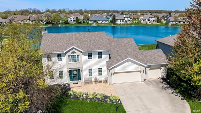 9529 Skipjack Cv, Fort Wayne, IN 46835 - view of front of home with a garage, a residential view, concrete driveway, a water view, and roof with shingles
