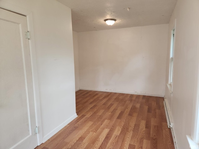 706 S Western Ave, Marion, IN 46952 - empty room featuring light wood-type flooring, baseboards, baseboard heating, and a textured ceiling