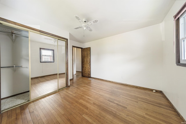 1209 E Water St, Mount Vernon, IN 47620 - unfurnished bedroom with wood-type flooring, baseboards, a ceiling fan, and a closet