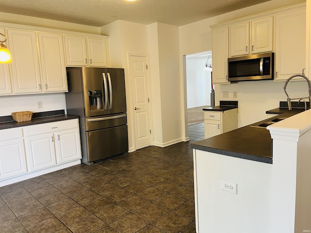 9987 Rainbow Falls Ln, Fishers, IN 46037 - kitchen featuring appliances with stainless steel finishes, dark countertops, white cabinets, and a sink