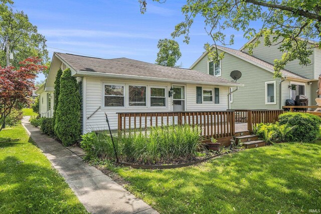 8056 E N Rd, Syracuse, IN 46567 - view of front of property featuring a wooden deck and a front lawn