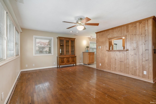 8056 E N Rd, Syracuse, IN 46567 - unfurnished living room with wooden walls, a ceiling fan, hardwood / wood-style flooring, and baseboards