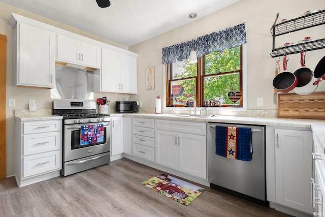 913 Cedar St, Elkhart, IN 46514 - kitchen featuring stainless steel appliances, a sink, light countertops, and white cabinets