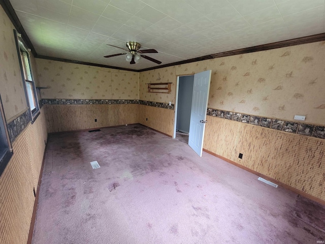257 Center St, Auburn, IN 46706 - carpeted empty room featuring wallpapered walls, crown molding, a ceiling fan, and wainscoting