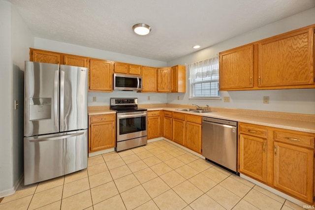 1888 Halyard Ct, West Lafayette, IN 47906 - kitchen featuring stainless steel appliances, a sink, light tile patterned floors, light countertops, and brown cabinetry