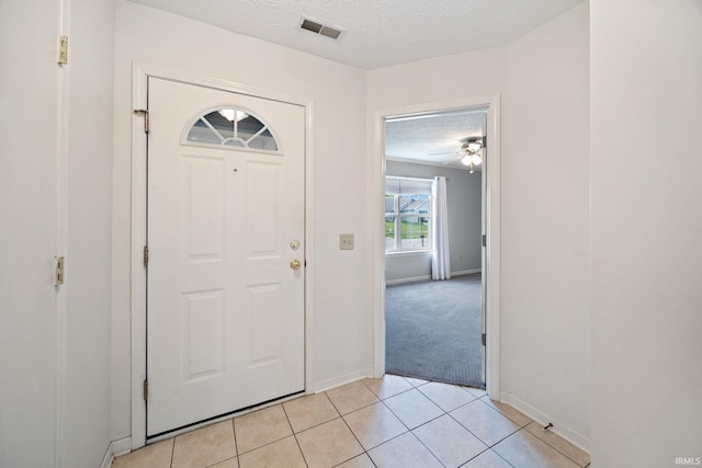 1888 Halyard Ct, West Lafayette, IN 47906 - foyer entrance featuring light tile patterned floors, a textured ceiling, baseboards, and light carpet
