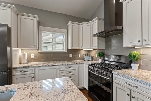 7503 Toscana Ct, Granger, IN 46530 - kitchen featuring wall chimney range hood, range with two ovens, freestanding refrigerator, lofted ceiling, and tasteful backsplash