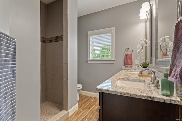 7503 Toscana Ct, Granger, IN 46530 - full bathroom with double vanity, toilet, wood finished floors, a stall shower, and baseboards