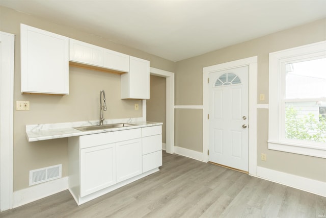 1002 S 33rd St, South Bend, IN 46615 - kitchen featuring a sink, light wood finished floors, white cabinets, and baseboards