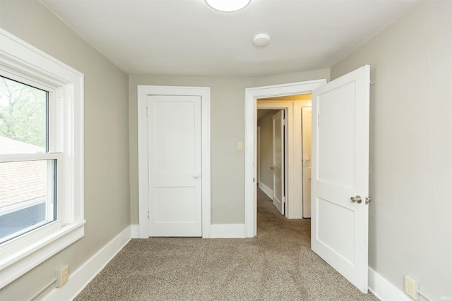 1002 S 33rd St, South Bend, IN 46615 - unfurnished bedroom featuring light carpet, multiple windows, and baseboards