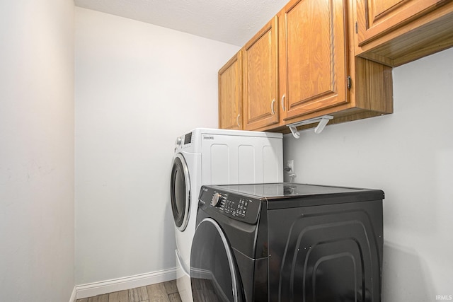 15711 Durham Way, Granger, IN 46530 - washroom featuring cabinet space, light wood-style flooring, baseboards, and washer and clothes dryer