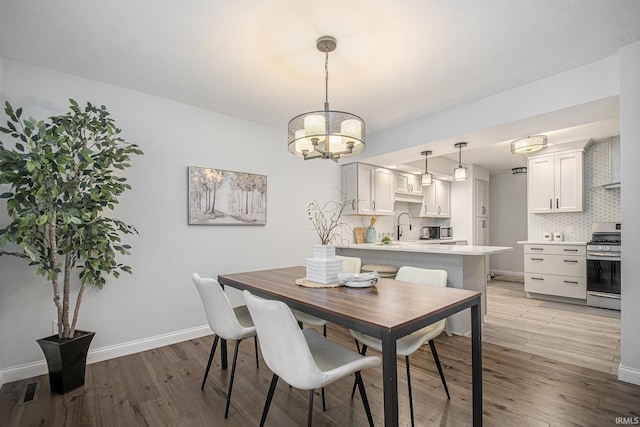 15711 Durham Way, Granger, IN 46530 - dining space featuring a chandelier, light wood-style flooring, and baseboards