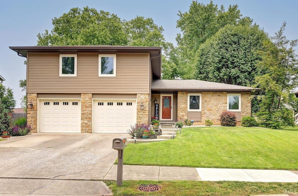 1350 E Browning Ct, Bloomington, IN 47401 - split level home featuring stone siding, an attached garage, driveway, and a front lawn