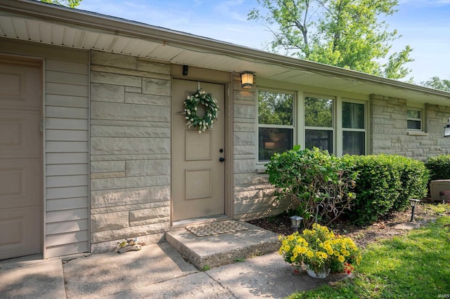 2408 W Sheffield Dr, Muncie, IN 47304 - property entrance featuring a garage and stone siding