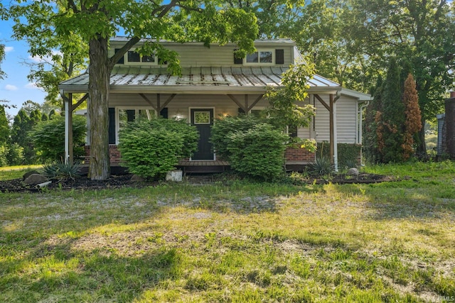 6226 Wheeling Ave, Muncie, IN 47304 - view of front facade featuring a standing seam roof, a front yard, metal roof, and brick siding