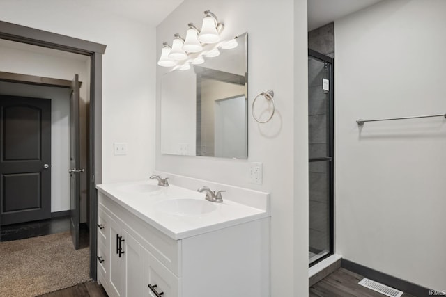 6226 Wheeling Ave, Muncie, IN 47304 - bathroom with wood finished floors, a shower stall, double vanity, and baseboards