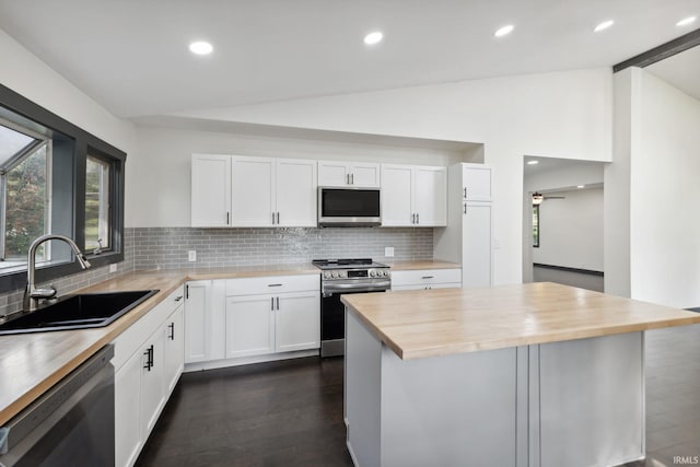 6226 Wheeling Ave, Muncie, IN 47304 - kitchen with appliances with stainless steel finishes, a sink, lofted ceiling, wood counters, and decorative backsplash
