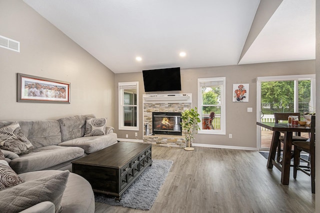 5206 Windfall Ct, South Bend, IN 46619 - living room with lofted ceiling, baseboards, wood finished floors, a stone fireplace, and recessed lighting