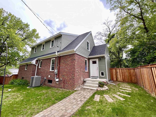 1500 N Grant St, West Lafayette, IN 47906 - rear view of house featuring central AC unit, brick siding, and roof with shingles