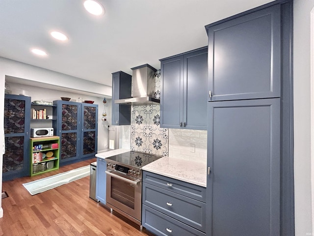 1500 N Grant St, West Lafayette, IN 47906 - kitchen with electric stove, wall chimney range hood, white microwave, light wood-style floors, and tasteful backsplash
