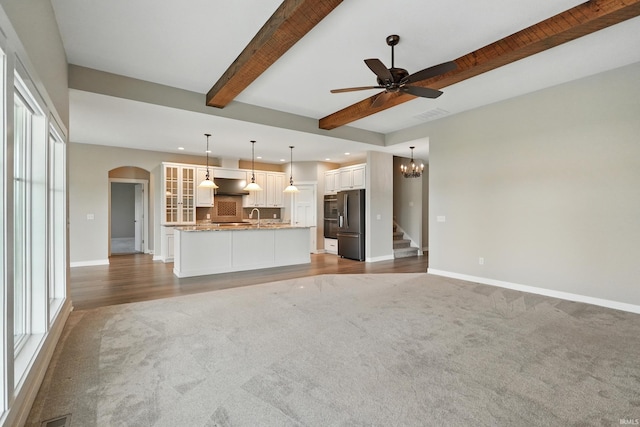 13769 Montoro Ct, Fort Wayne, IN 46845 - unfurnished living room with carpet floors, arched walkways, recessed lighting, beam ceiling, and a chandelier