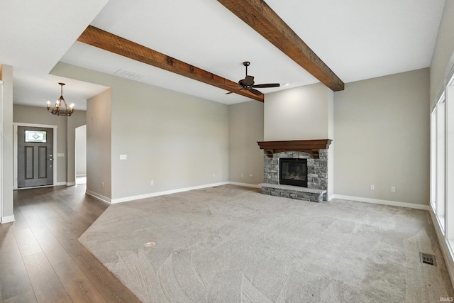 13769 Montoro Ct, Fort Wayne, IN 46845 - unfurnished living room featuring a ceiling fan, a chandelier, beamed ceiling, a stone fireplace, and baseboards
