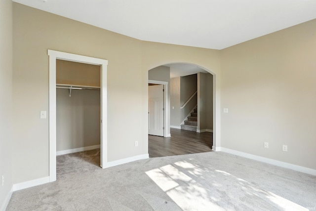 13769 Montoro Ct, Fort Wayne, IN 46845 - unfurnished bedroom featuring carpet flooring, arched walkways, a walk in closet, and baseboards