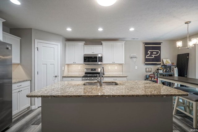 1757 Mill Pond Ln, Lafayette, IN 47905 - kitchen featuring appliances with stainless steel finishes, a sink, backsplash, a center island with sink, and light stone counters