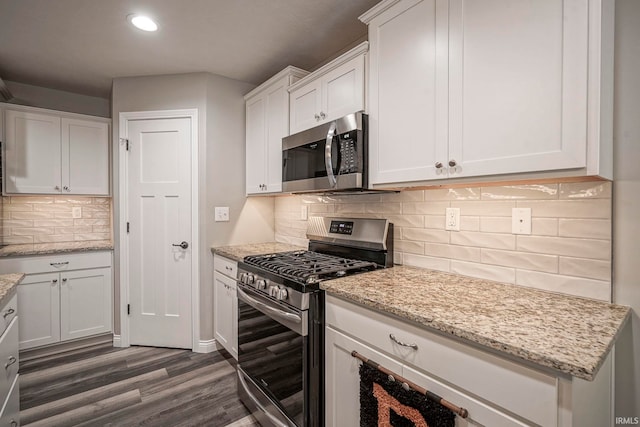 1757 Mill Pond Ln, Lafayette, IN 47905 - kitchen featuring appliances with stainless steel finishes, dark wood finished floors, white cabinetry, recessed lighting, and backsplash