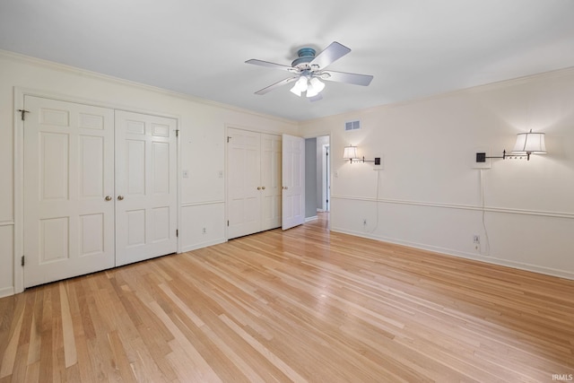 201 Colony Rd, West Lafayette, IN 47906 - unfurnished bedroom with two closets, crown molding, light wood-style floors, baseboards, and ceiling fan