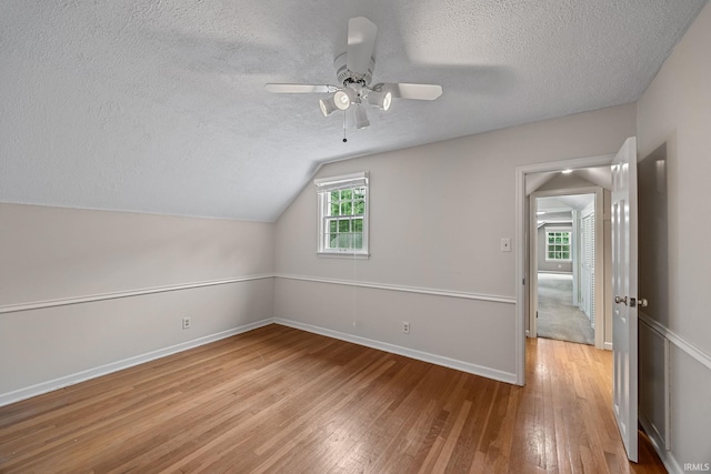 201 Colony Rd, West Lafayette, IN 47906 - additional living space featuring a textured ceiling, light wood-style floors, ceiling fan, lofted ceiling, and baseboards
