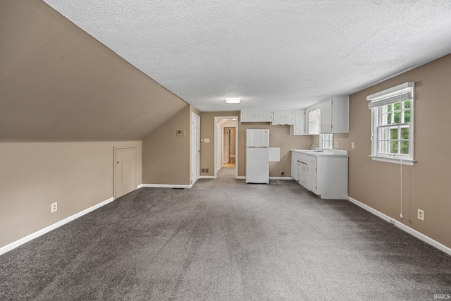 201 Colony Rd, West Lafayette, IN 47906 - unfurnished living room with a sink, a textured ceiling, dark colored carpet, and baseboards