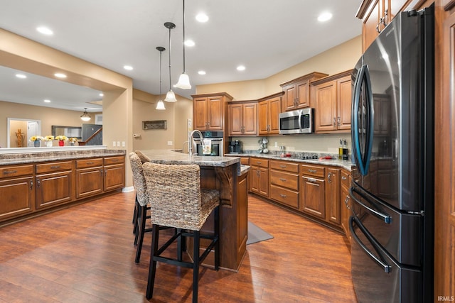 15829 Winterberry Ct, Huntertown, IN 46748 - kitchen featuring stainless steel appliances, brown cabinets, dark wood finished floors, a breakfast bar, and hanging light fixtures