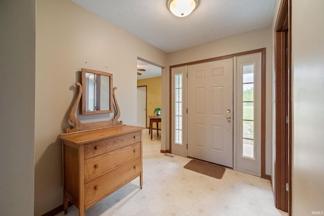8633 State Rd 28 E, Clarks Hill, IN 47930 - entryway with light floors, a textured ceiling, and baseboards
