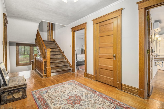 831 W Colfax Ave, South Bend, IN 46601 - entrance foyer with hardwood / wood-style flooring, stairs, crown molding, baseboards, and a textured ceiling