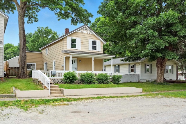 211 N Poplar St, Lagrange, IN 46761 - view of front of house with a porch, a front yard, and a chimney