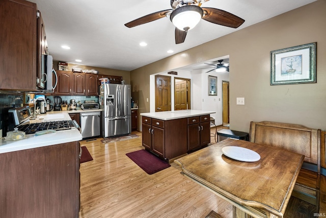 30986 Creekwood Ter, Osceola, IN 46561 - kitchen with stainless steel appliances, a ceiling fan, light countertops, dark brown cabinets, and a kitchen island