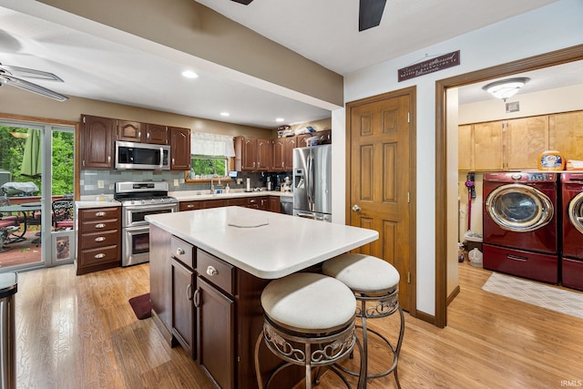 30986 Creekwood Ter, Osceola, IN 46561 - kitchen featuring a ceiling fan, washing machine and dryer, stainless steel appliances, light countertops, and light wood-style floors