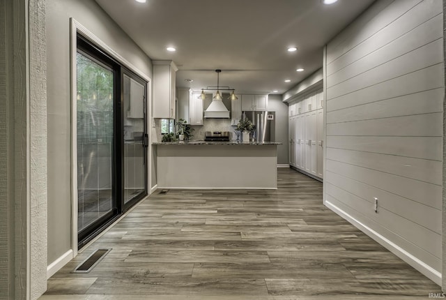 1212 Summit Ave, Bluffton, IN 46714 - kitchen featuring premium range hood, stove, recessed lighting, dark wood-style floors, and a peninsula